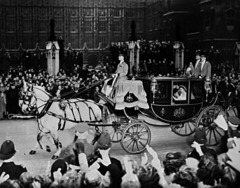 Queen Elizabeth II (in coach) and her husband Prince Philip, Duke of Edinburgh are cheered by the crowd after their wedding ceremony, on November 20, 1947, on their road to Buckingham Palace, London.