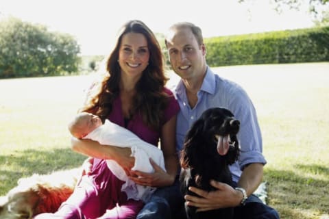 Catherine, Duchess of Cambridge and Prince William, Duke of Cambridge pose for a photograph with their son, Prince George of Cambridge, and Lupo, the couple's cocker spaniel.