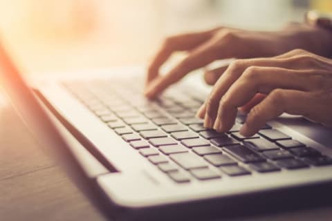 A person types on a laptop