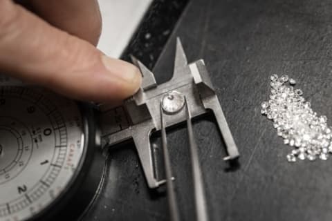 A jeweler measures a diamond