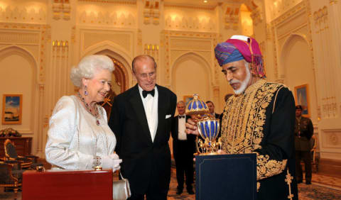 Queen Elizabeth II and Prince Philip, Duke of Edinburgh are presented with a gold musical Faberge style egg by the Sultan of Oman, before a State Banquet at his Palace on November 26, 2010 in Muscat, Oman