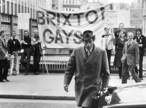 Jeremy Thorpe arrives at the Old Bailey, where he was being tried on charges of conspiracy and incitement to murder, while gay rights supporters protest in the background.