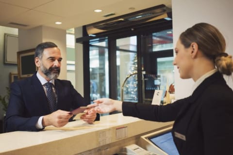 man pays bill at the hotel desk