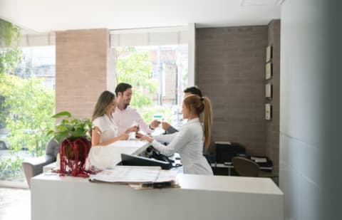 couples checks into hotel at reception desk