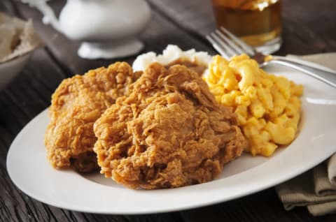 A plate of fried chicken, macaroni and cheese, and mashed potatoes.