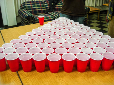 A lot of red cups set up for a game of beer pong.