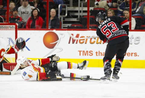 Jan 24, 2016; Raleigh, NC, USA; Calgary Flames defensemen Kris Russell (4) blocks the first period shot attempt by Carolina Hurricanes forward Jeff Skinner (53) at PNC Arena. Mandatory Credit: James Guillory-USA TODAY Sports