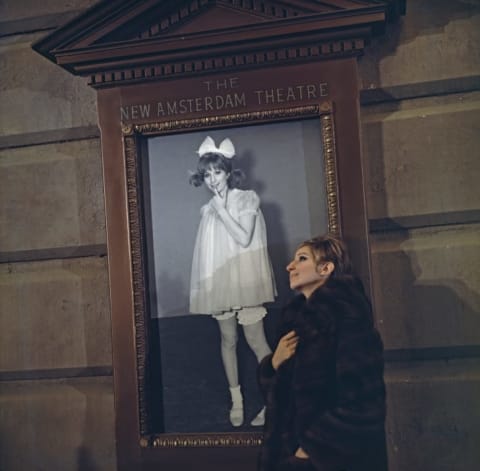 Barbra Streisand next to her Funny Girl poster.