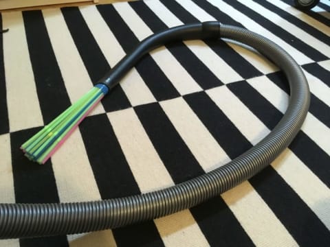 A vacuum with an attachment made out of straws.