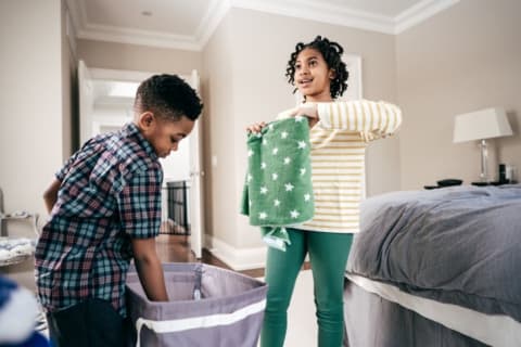 Two kids folding the laundry.