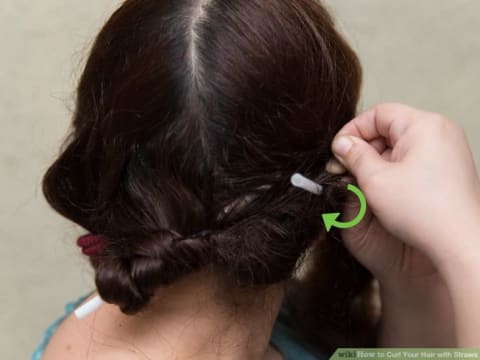 A person using straws to curl her hair.