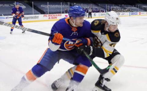 UNIONDALE, NEW YORK – JANUARY 18: Ryan Pulock #6 of the New York Islanders and Jake DeBrusk #74 of the Boston Bruins pursue the puck during the first period at Nassau Coliseum on January 18, 2021 in Uniondale, New York. (Photo by Bruce Bennett/Getty Images)