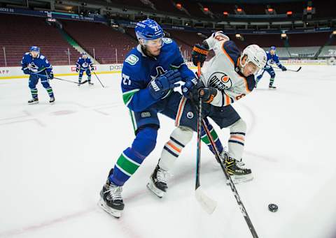 May 3, 2021; Vancouver, British Columbia, CAN; Vancouver Canucks defenseman Travis Hamonic (27) checks Edmonton Oilers forward Tyler Ennis (63) in the third period at Rogers Arena. Oilers won 5-3. Mandatory Credit: Bob Frid-USA TODAY Sports