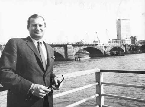 Robert McCaulloch standing in front of London Bridge as it is dismantled in 1968.