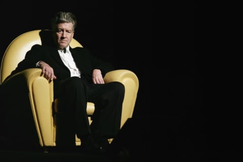 David Lynch seated in a large yellow chair.