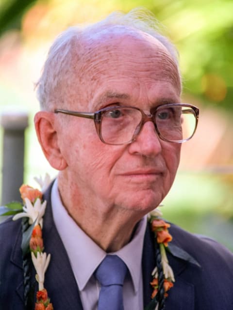 James Michener wearing a flower necklace.