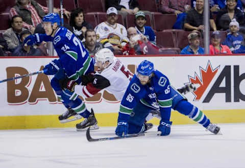 Sep 28, 2015; Vancouver, British Columbia, CAN; Arizona Coyotes defenceman Connor Murphy (5) battles with Vancouver Canucks forward Adam Cracknell (24) and forward Alexandre Grenier (65) in the first period at Rogers Arena. Mandatory Credit: Bob Frid-USA TODAY Sports