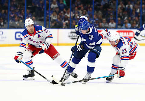 Nov 14, 2019; Tampa, FL, USA; Tampa Bay Lightning left wing Ondrej Palat (18) skates with the puck past New York Rangers center Chris Kreider (20) and New York Rangers defenseman Adam Fox (23) to score a goal during the first period at Amalie Arena. Mandatory Credit: Kim Klement-USA TODAY Sports