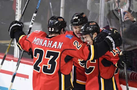 Feb 3, 2016; Calgary, Alberta, CAN; Calgary Flames left wing Johnny Gaudreau (13) celebrates his second period goal with center Sean Monahan (23) and center Jiri Hudler (24) against the Carolina Hurricanes at Scotiabank Saddledome. Mandatory Credit: Candice Ward-USA TODAY Sports