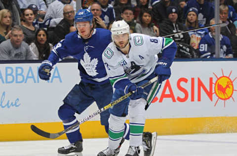 TORONTO, ON – FEBRUARY 29: Christopher Tanev #8 of the Vancouver Canucks skates after the puck against Kasperi Kapanen #24 of the Toronto Maple Leafs . (Photo by Claus Andersen/Getty Images)