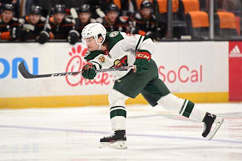 Feb 20, 2021; Anaheim, California, USA; Minnesota Wild defenseman Calen Addison (59) shoots the puck against the Anaheim Ducks during the first period at Honda Center. Mandatory Credit: Orlando Ramirez-USA TODAY Sports