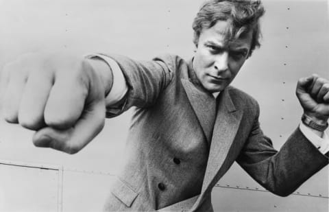 English actor Michael Caine, throwing a punch, August 1965