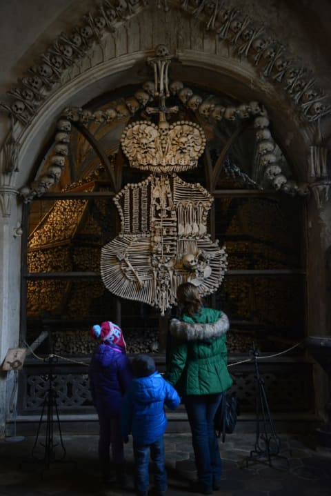 Visitors look at the coat of arms of the Schwarzenberg noble family at the Sedlec Ossuary chapel