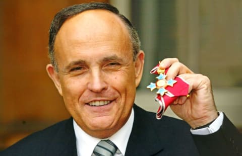 Former New York Mayor Rudolph Giuliani shows of his Knighthood of the British Empire (KBE) medal in 2002.