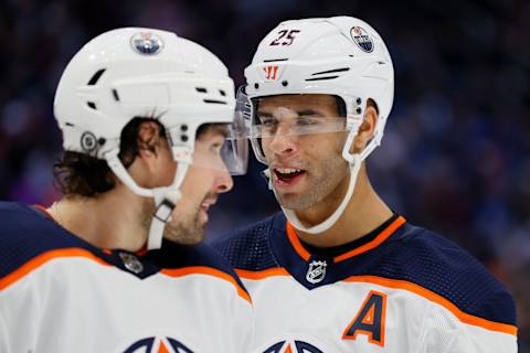 SEATTLE, WASHINGTON – DECEMBER 18: Cody Ceci #5 and Darnell Nurse #25 of the Edmonton Oilers talk against the Seattle Kraken during the second period at Climate Pledge Arena on December 18, 2021 in Seattle, Washington. (Photo by Steph Chambers/Getty Images)