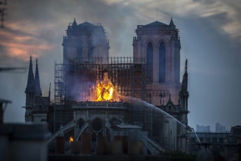 French firefighters work to extinguish the flames at Notre-Dame Cathedral. Here, the spire has already collapsed, but the main stone structure and bell towers were saved.