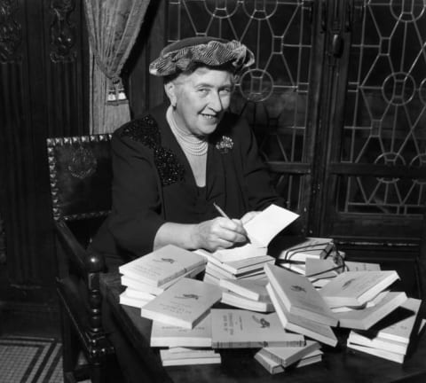 Author Agatha Christie autographing French editions of her books