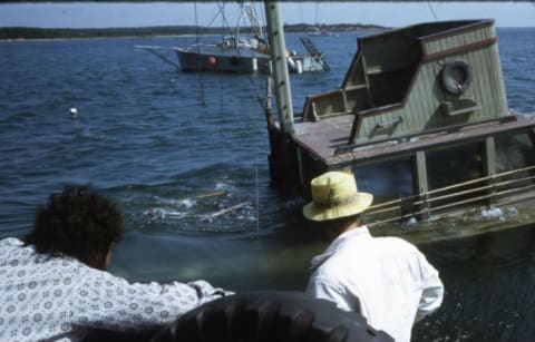 Joe Alves (L) and another crew member look on as the Orca II sinks on command.