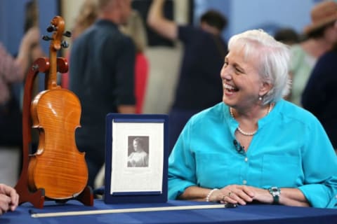 Antiques Roadshow appraiser Frederick Oster (off-camera) discusses a French violin circa 1875 with a guest.