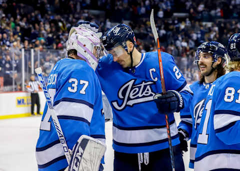 WINNIPEG, MB – NOVEMBER 11: Goaltender Connor Hellebuyck #37 of the Winnipeg Jets gets congratulated by teammate Blake Wheeler #26 following a 5-2 victory over the New Jersey Devils at the Bell MTS Place on November 11, 2018 in Winnipeg, Manitoba, Canada. (Photo by Darcy Finley/NHLI via Getty Images)