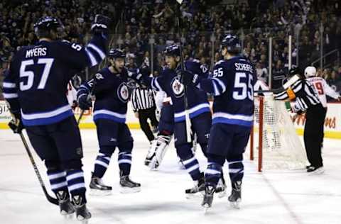 Mar 21, 2015; Winnipeg, Manitoba, CAN; Winnipeg Jets defenseman Tyler Myers (57) and right wing Drew Stafford (12) and right wing Blake Wheeler (26) celebrate a goal by center Mark Scheifele (55) in the second period at MTS Centre. Mandatory Credit: James Carey Lauder-USA TODAY Sports