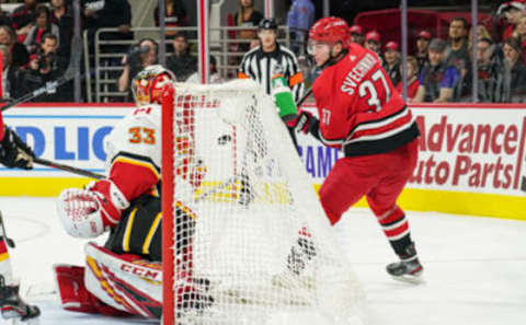 RALEIGH, NC – OCTOBER 29: Carolina Hurricanes Left Wing Andrei Svechnikov (37) uses a lacrosse move to lift the puck behind Calgary Flames Goalie David Rittich (33) during a game between the Calgary Flames and the Carolina Hurricanes at the PNC Arena in Raleigh, NC on October 29, 2019. (Photo by Greg Thompson/Icon Sportswire via Getty Images)