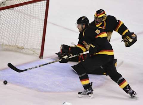 Feb 13, 2016; Vancouver, British Columbia, CAN; Vancouver Canucks defenseman Christopher Tanev (8) reaches for the puck after a shot on net by the Toronto Maple Leafs during the second period at Rogers Arena. Mandatory Credit: Anne-Marie Sorvin-USA TODAY Sports