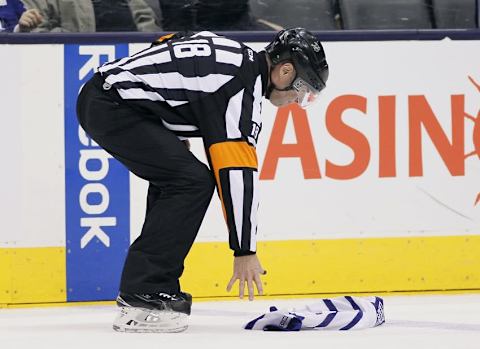 Jan 19, 2015; Toronto, Ontario, CAN; NHL referee Greg Kimmerly picks up a Toronto Maple Leafs jersey during a break in the action against the Carolina Hurricanes at the Air Canada Centre. Carolina defeated Toronto 4-1. Mandatory Credit: John E. Sokolowski-USA TODAY Sports