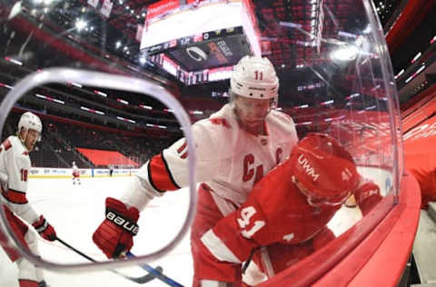 Mar 14, 2021; Detroit, Michigan, USA; Carolina Hurricanes center Jordan Staal (11) hits Detroit Red Wings center Luke Glendening (41) during the second period at Little Caesars Arena. Mandatory Credit: Tim Fuller-USA TODAY Sports