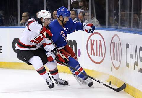 Sep 29, 2016; New York, NY, USA; New Jersey Devils defenseman Yohann Auvitu (33) and New York Rangers defenseman Chris Summers (55) fight for the puck during the first period of a preseason hockey game at Madison Square Garden. Mandatory Credit: Brad Penner-USA TODAY Sports