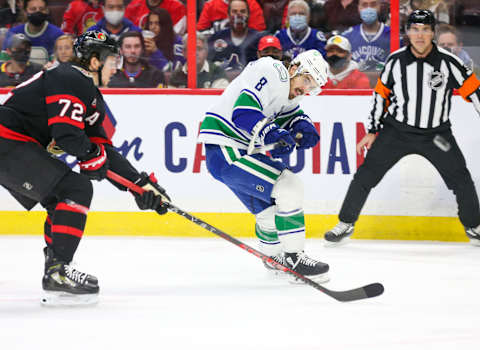 OTTAWA, ONTARIO – DECEMBER 01: Conor Garland #8 of the Vancouver Canucks shoots the puck at the net as Thomas Chabot #72 of the Ottawa Senators looks on during the first period at Canadian Tire Centre on December 01, 2021 in Ottawa, Ontario. (Photo by Chris Tanouye/Getty Images)