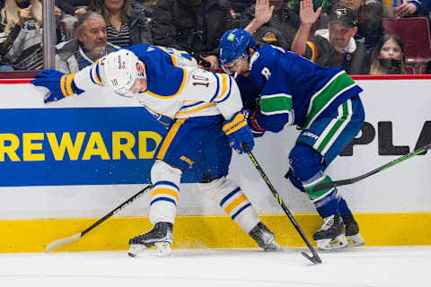 Mar 20, 2022; Vancouver, British Columbia, CAN; Buffalo Sabres defenseman Henri Jokiharju (10) battles with Vancouver Canucks forward Conor Garland (8) in the first period at Rogers Arena. Mandatory Credit: Bob Frid-USA TODAY Sports