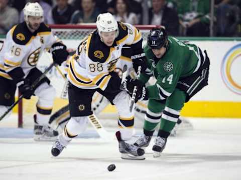 Feb 20, 2016; Dallas, TX, USA; Boston Bruins left wing David Pastrnak (88) and Dallas Stars left wing Jamie Benn (14) fight for the puck during the third period at the American Airlines Center. The Bruins defeat the Stars 7-3. Mandatory Credit: Jerome Miron-USA TODAY Sports