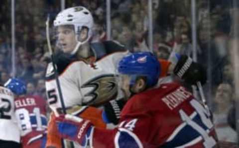 Mar 22, 2016; Montreal, Quebec, CAN; Anaheim Ducks defenseman Korbinian Holzer (5) checks Montreal Canadiens forward Tomas Plekanec (14) into the boards during the second period at the Bell Centre. Mandatory Credit: Eric Bolte-USA TODAY Sports