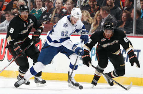 ANAHEIM, CA: Andrej Sustr #62 of the Tampa Bay Lightning handles the puck against Emerson Etem #65 and Teemu Selanne #8 of the Anaheim Ducks on November 22, 2013. (Photo by Debora Robinson/NHLI via Getty Images)