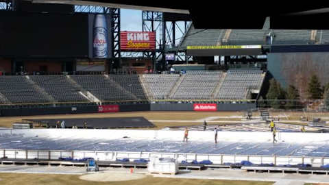 Workers on the ice at Coors Field.