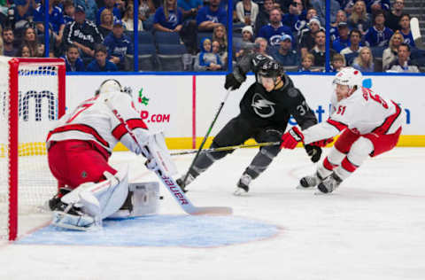 TAMPA, FL – NOVEMBER 30: Yanni Gourde #37 of the Tampa Bay Lightning skates against goalie James Reimer #47 and Jake Gardiner #51 of the Carolina Hurricanes during the first period at Amalie Arena on November 30, 2019 in Tampa, Florida. (Photo by Scott Audette /NHLI via Getty Images)