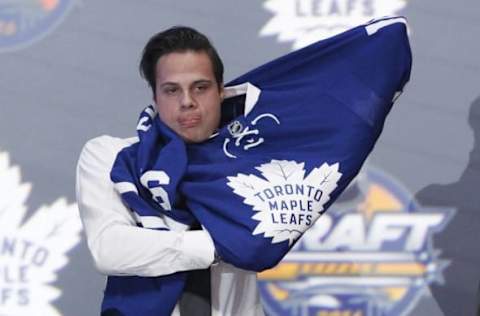 Jun 24, 2016; Buffalo, NY, USA; Auston Matthews puts on a team jersey after being selected as the number one overall draft pick by the Toronto Maple Leafs in the first round of the 2016 NHL Draft at the First Niagra Center. Mandatory Credit: Timothy T. Ludwig-USA TODAY Sports