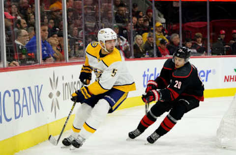 RALEIGH, NC – NOVEMBER 29: Dan Hamhuis #5 of the Nashville Predators controls the puck away from Sebastian Aho #20 of the Carolina Hurricanes during an NHL game on November 29, 2019 at PNC Arena in Raleigh, North Carolina. (Photo by Gregg Forwerck/NHLI via Getty Images)