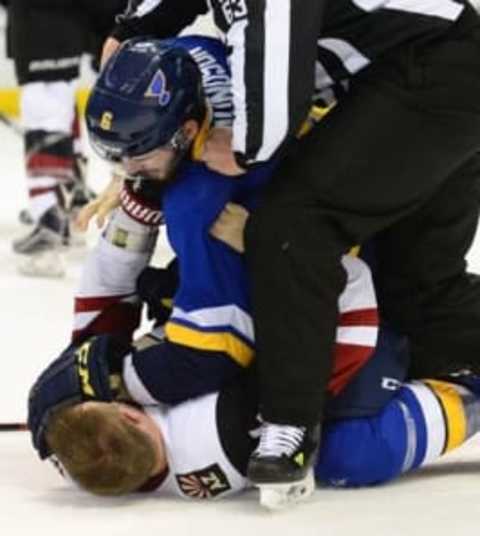 Apr 4, 2016; St. Louis, MO, USA; St. Louis Blues defenseman Joel Edmundson (6) fights with Arizona Coyotes defenseman Kevin Connauton (44) as linesman Trent Knorr (63) breaks up the fight during the second period at Scottrade Center. Mandatory Credit: Jeff Curry-USA TODAY Sports